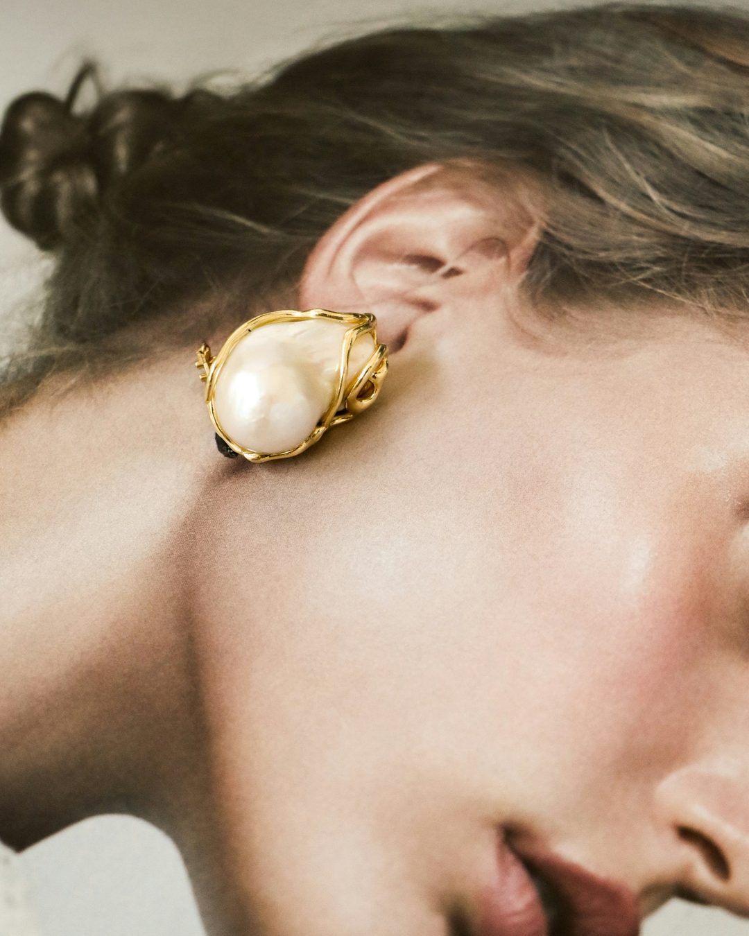Profile of a woman wearing a lustrous pearl earring