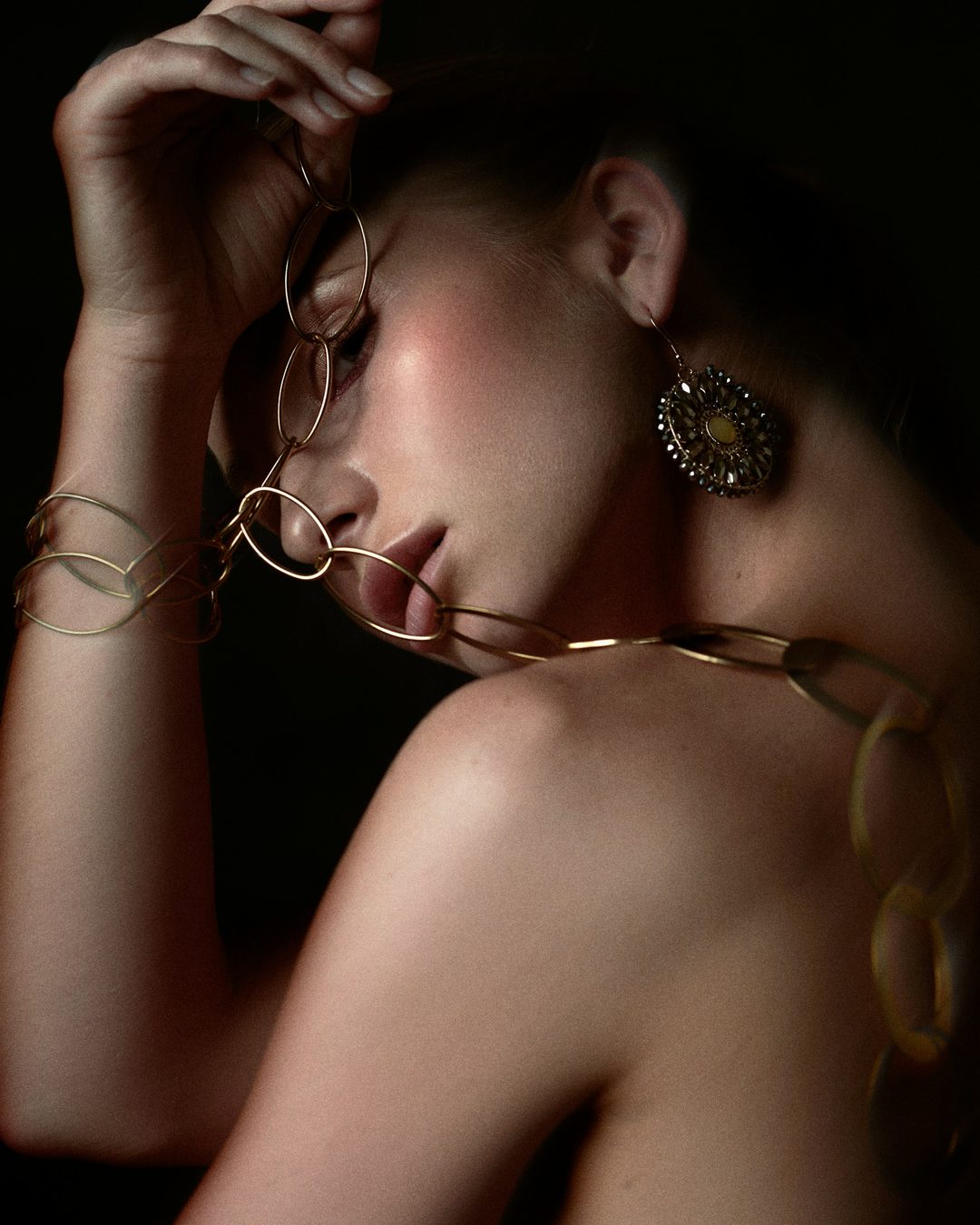 A dramatic portrait of a woman wearing statement earrings