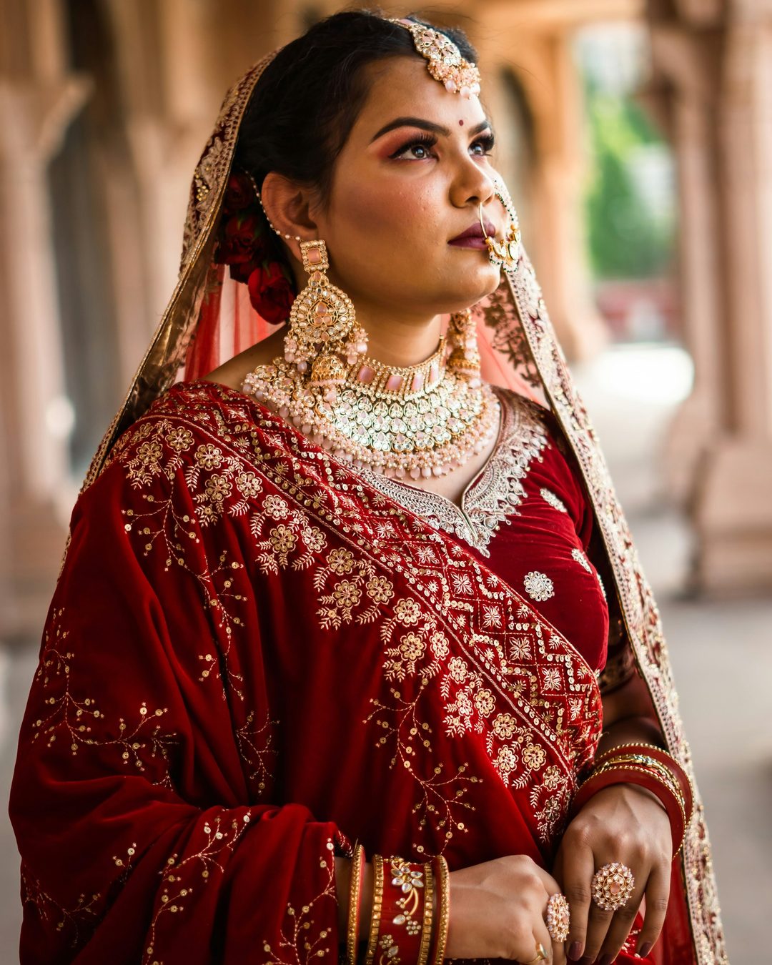 A bride in red wearing layered festive jewellery